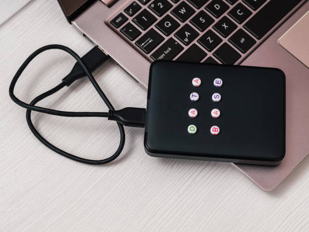 istock Hard disk, labeled base and the laptop on a light table. Flat lay. The concept of backup storage. 1147686258