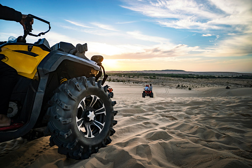 Summer offroad adventure on atv in sand quarry. Entertainment of tourists in the desert in MUI ne in Vietnam. Off-road ATV wheel close-up