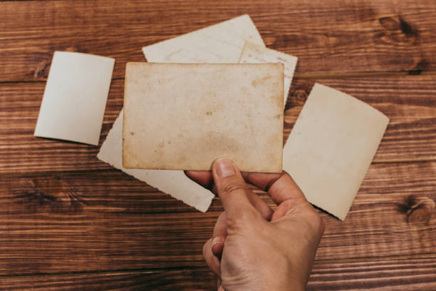 istock Stack old photos on table. Mock-up blank paper. Postcard rumpled and dirty vintage. Retro card 1147690912
