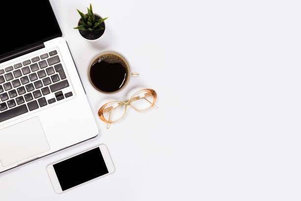 istock Modern workspace with coffee cup, smartphone, paper, notebook, tablet and laptop copy space on white color background. Top view. Flat lay style. 1147690964