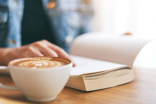 istock a woman holding and reading a vintage novel book 1147701606