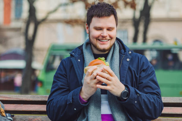 istock young adult man eating hamburger 1147706449