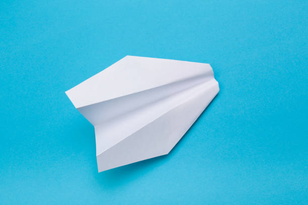 istock Flat lay of white paper planes on blue background with text space. - Image 1147708276