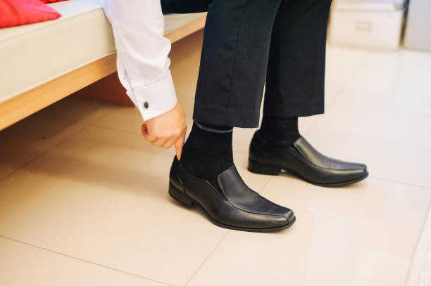 istock Bridegroom wearing a black leather shoe 1147709868