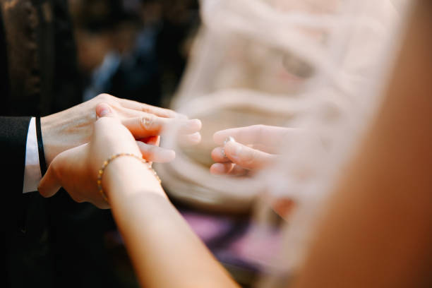 istock Bridegroom putting on the wedding ring for the bride 1147710028