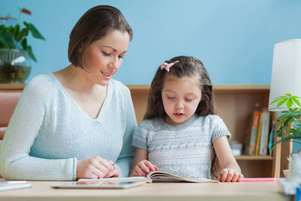 istock Mother and daughter reading in home work office 1147712630
