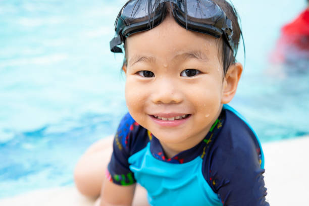 little boy playing in swimming pool - swimming child swimwear little boys imagens e fotografias de stock