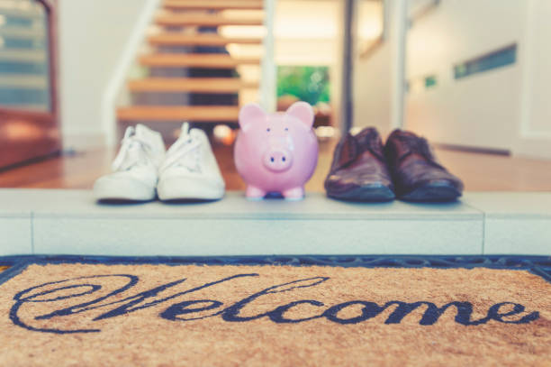 istock Saving for a new home concept. Piggy bank standing at front door 1147713385