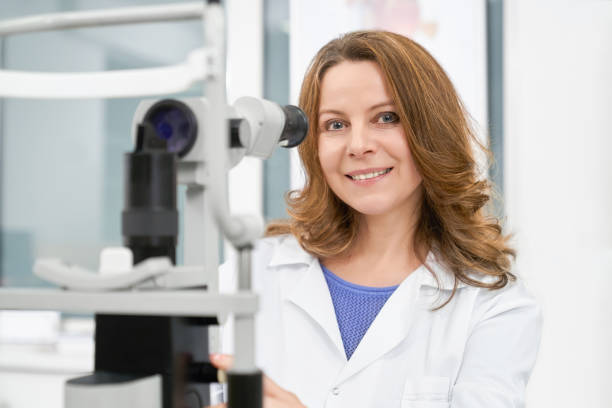 istock Doctor optometrist in white coat posing with slit lamp. 1147713521