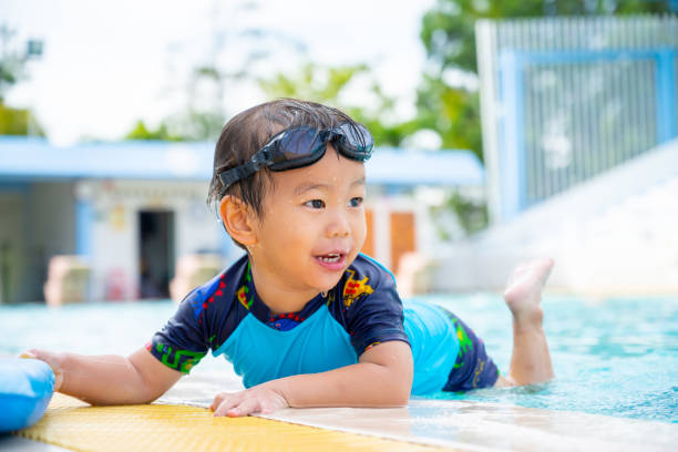 istock Little boy playing in swimming pool 1147713525