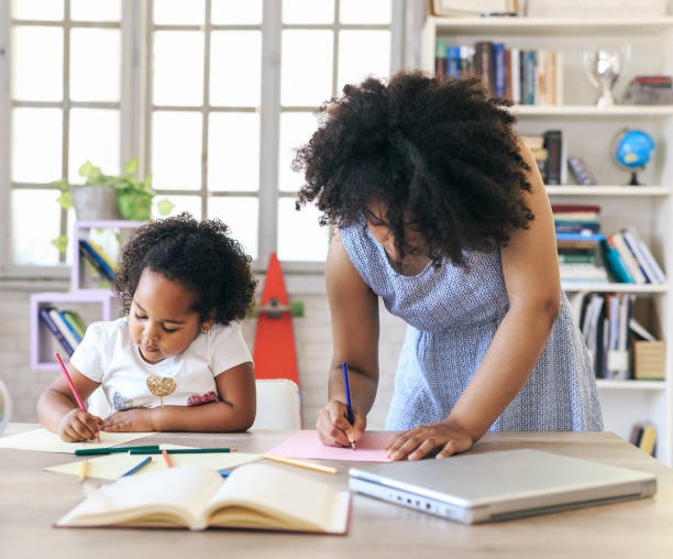istock Young woman and a child writing together 1147713796