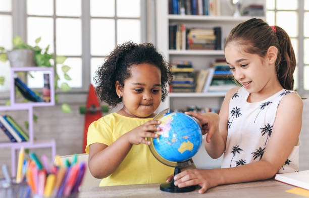 istock Two girls examining a globe 1147713881