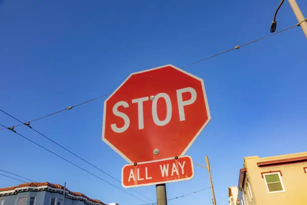 red stop sign with comment all way under blue sky