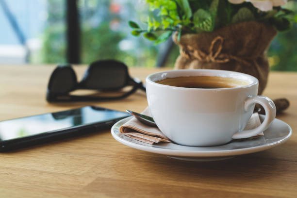 istock Black coffee in white ceramic cup and artificial flowers 1147717406