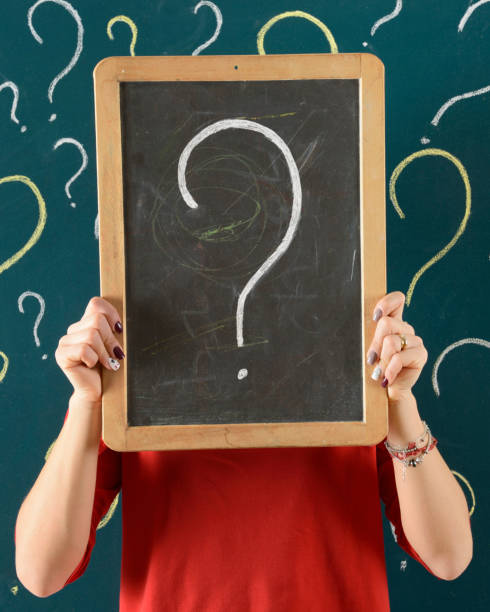 istock Making Decision Concept. Woman showing question mark on blackboard . 1147727548