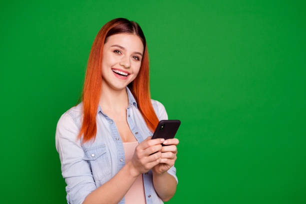istock Portrait cute pretty youngster content glad rejoice free time use user apps programs chat text type information notification laugh wear denim clothing long straight hairdo isolated vibrant background 1147727983