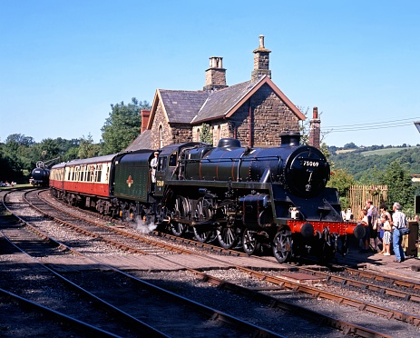 Close up of a suspension unit and wheel on an old railway carriage running on railroad tracks in England.