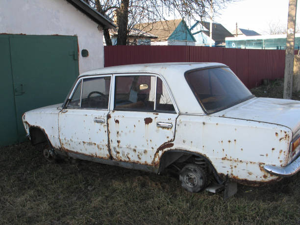 istock old rusty white car without wheels outdoor 1147738238