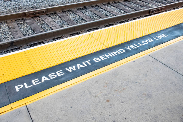 istock train platform with sign please wait behind the yellow line and yellow marked warning area 1147738318