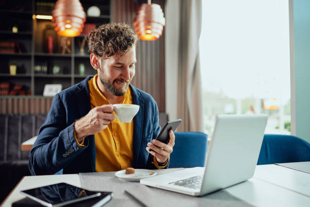 geschäftsmann trinkt kaffee und benutzt smartphone im café. - smart phone business person computer businessman stock-fotos und bilder