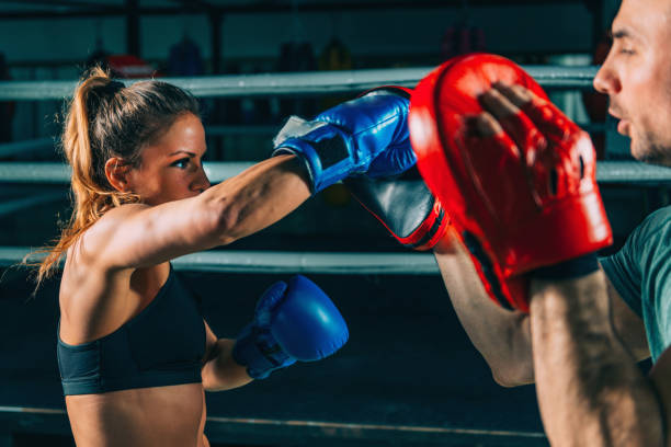 istock Woman on boxing training with trainer 1147745420