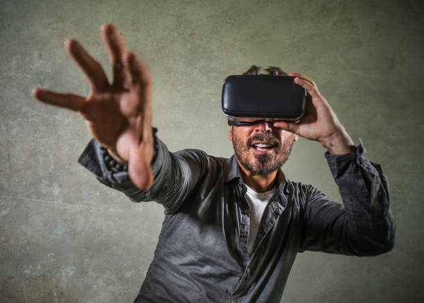 istock young happy and excited man wearing virtual reality VR goggles headset experimenting 3d illusion playing video game touching illusion environment surprised isolated on studio background 1147745532