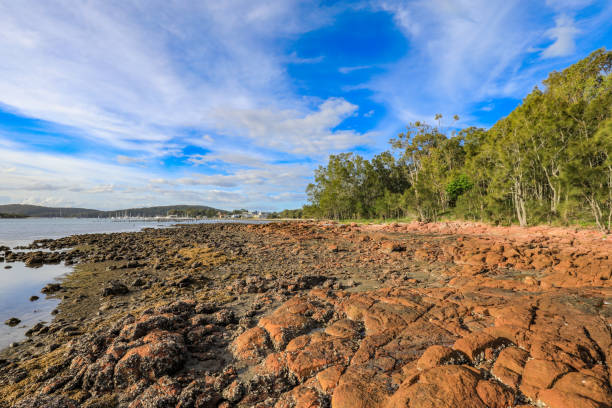 istock Rocky coastline at low tide leading to cloudy blue sky 1147747028