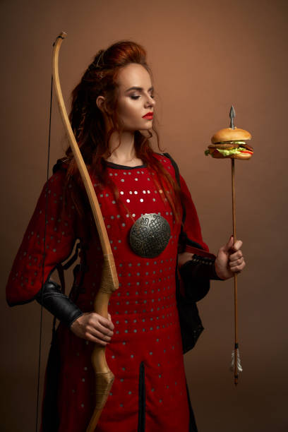 istock Female warrior holding arrow with hamburger, posing. 1147749294
