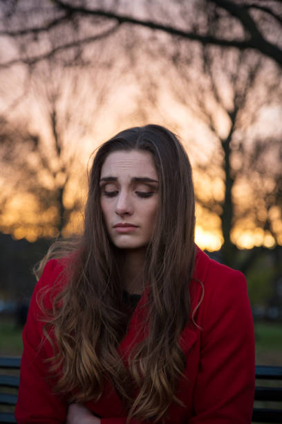 istock Woman looking down and unhappy in a park 1147751557
