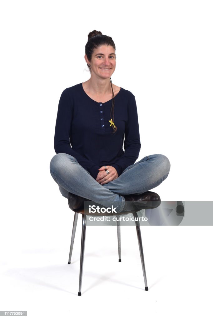 portrait of a woman on white woman sitting in a vintage chair with the lotus pose Adult Stock Photo