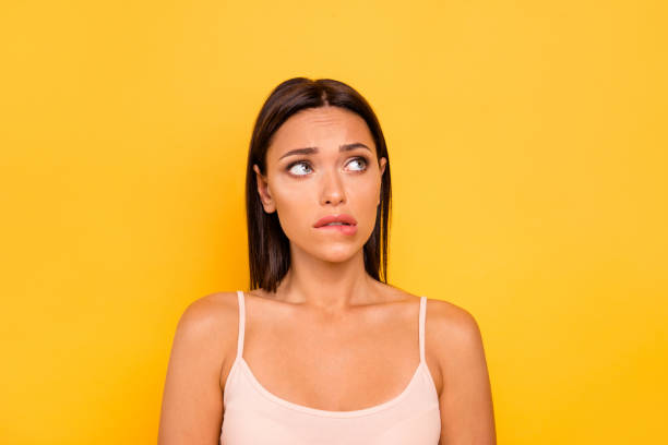 istock Close up photo beautiful she her lady look empty space fear hide eyes bite lip bad wrong unsuitable situation feel guilty wear casual pastel tank-top outfit clothes isolated yellow bright background 1147756128