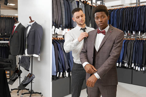 istock African man in boutique trying on, choosing elegant suit. 1147758531