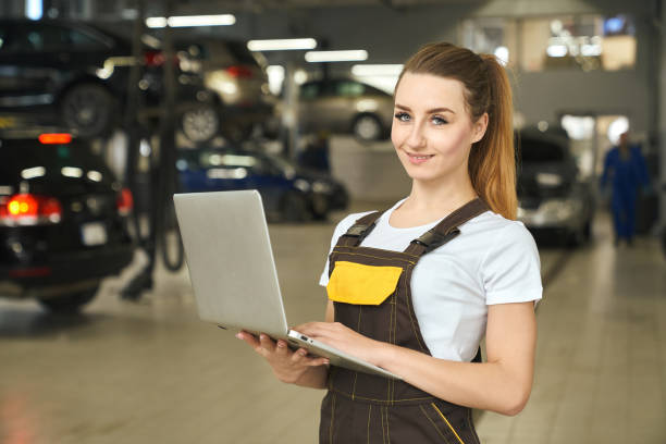 istock Pretty girl, mechanic posing with notebook in autoservice. 1147759085