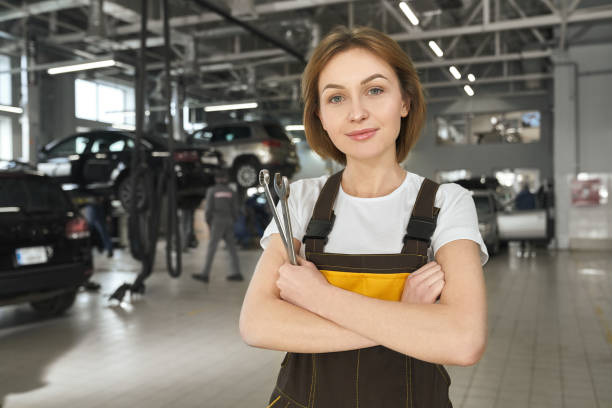 istock Female mechanic with wrenches posing in autoservice. 1147759095