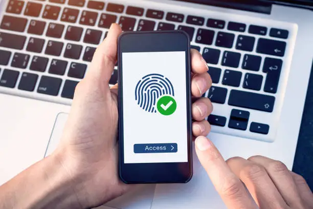 Photo of Secure access granted by valid fingerprint scan, cyber security on internet with biometrics authentication technology on mobile phone screen, person holding smartphone connected with wifi