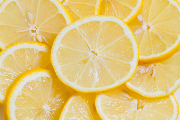 istock Fresh yellow lemons slices on wooden background 1147764585