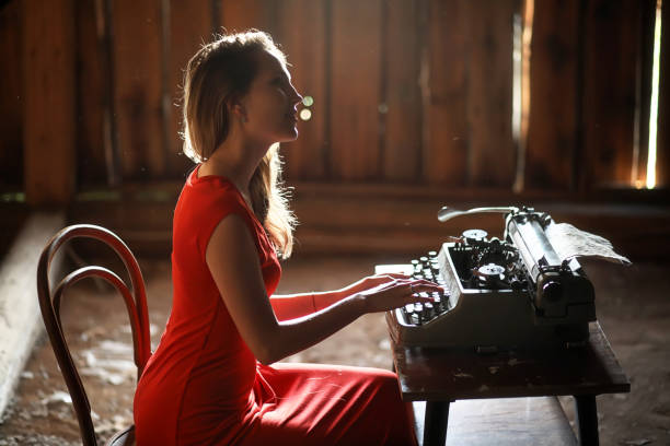 istock A girl in retro style prints on an old typewriter 1147765288