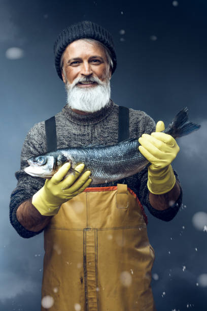 Fisherman with a big fish on stormy background