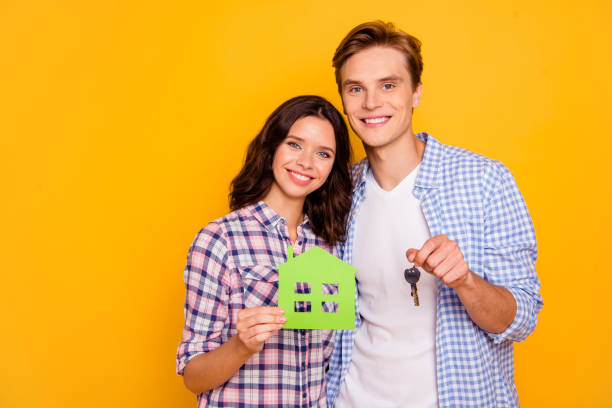 feche acima da foto do abraço ereto do hug dos pares abraçá-lo ele seu ela suas mãos do menino da senhora que prendem acessórios dos apartamentos novos desgastam o equipamento ocasional das camisas de manta isolado no fundo amarelo - key house home interior key ring - fotografias e filmes do acervo