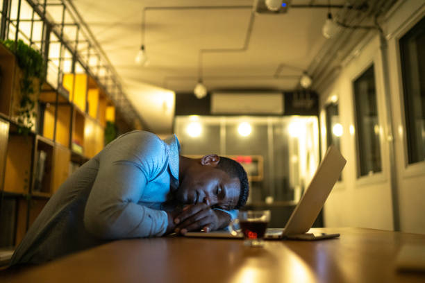 un hombre de negocios agotado descansando en su escritorio - exhaustion tired men after work fotografías e imágenes de stock