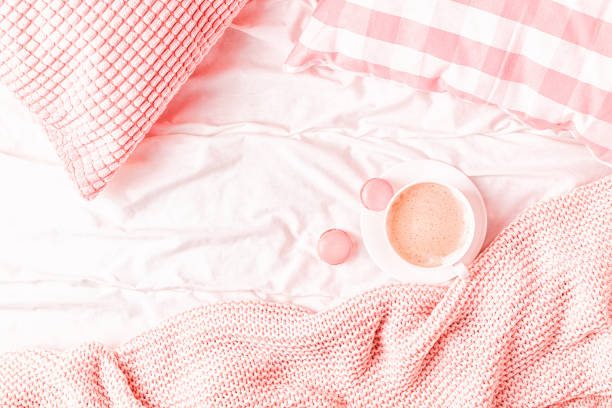 istock Bed with pink knitted plaid, coffee and macaroons 1147769273