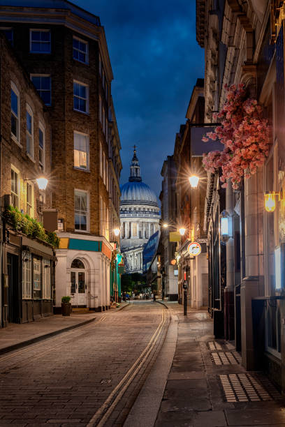 The illuminated alleys of London towards St. Pauls Cathedral in London, UK View among the illuminated alleys of London towards St. Pauls Cathedral in London, UK, during evening time alley photos stock pictures, royalty-free photos & images