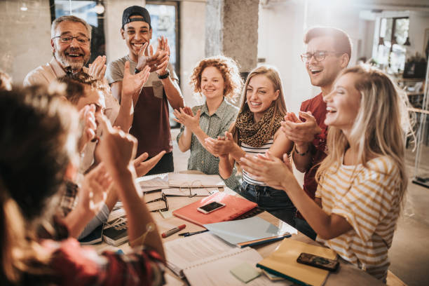 istock Happy university students and their teacher applauding at campus. 1147770410