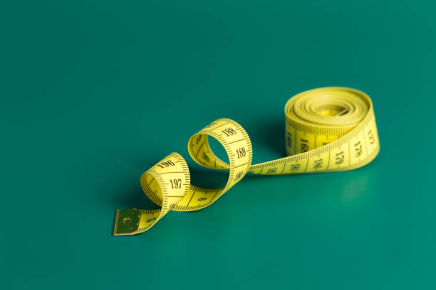 istock measure tape on a green background 1147771058