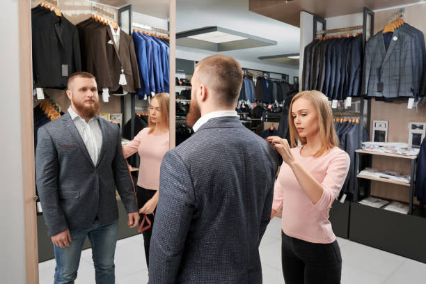 istock Man trying jacket while assistant measuring length of sleeve 1147771648