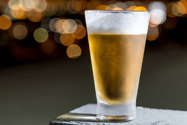 istock Beer glass over blurred cityscape background 1147772336