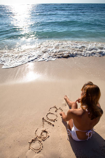 istock woman drawing numbers on the beach 1147777662
