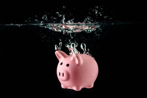 crisis concept, drowning piggy bank - debt finance despair water imagens e fotografias de stock