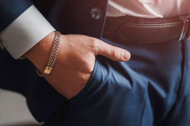 détail du corps d’un homme d’affaires. main de gros plan avec la chaîne de bijoux dans la poche - costume jewelry photos et images de collection