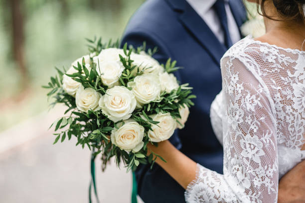 glückliche braut und bräutigam auf ihrer hochzeit umarmung - cut flowers fotos stock-fotos und bilder